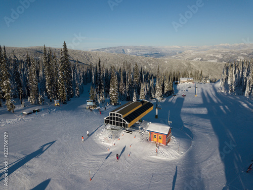 Aerial photo of skiing trails and runs go through the beautiful forest covered mountains photo