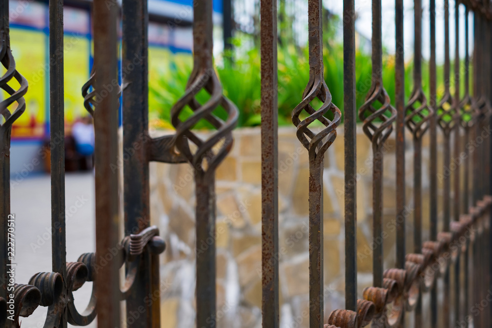 Old beautiful decorative metal wrought fence with artistic forging. Iron rusty guardrail need to be painting and repaired.