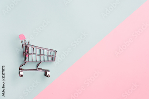 Close up of supermarket grocery push cart for shopping with black wheels on white background. Concept of shopping. photo