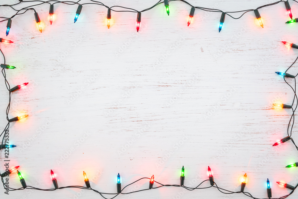 Christmas lights bulb frame decoration on white wood. Merry Christmas and New Year holiday background. top view - obrazy, fototapety, plakaty 