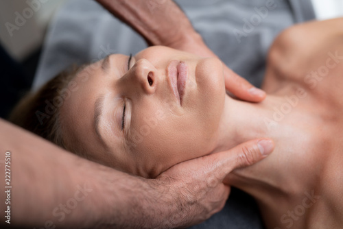 Pleasure. Close up portrait of charming lady with closed eyes receiving body treatment at spa salon