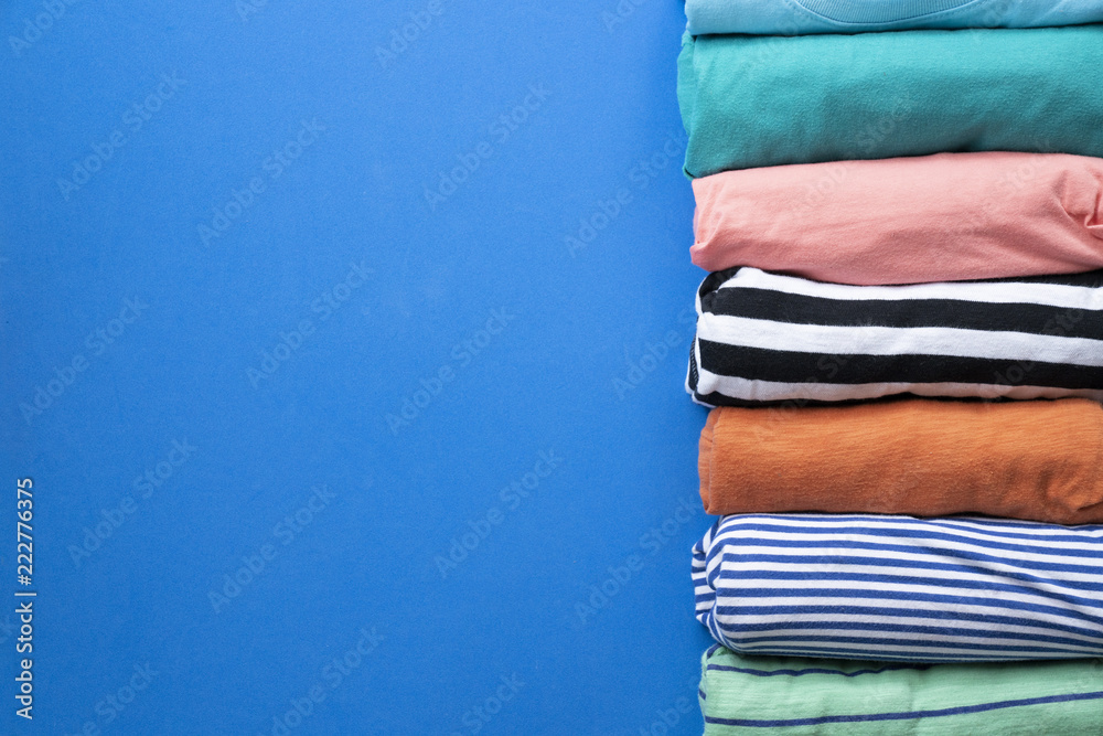 close up of rolled colorful clothes on blue background