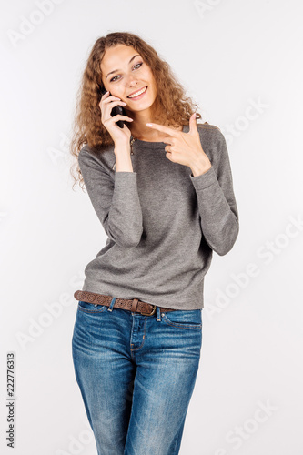 woman holding mobile phone and pointing finger over white background