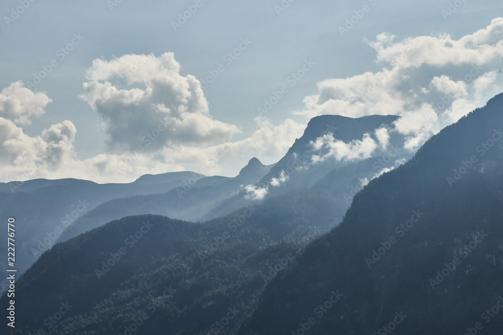 Scenic view of misty mountains above Halstatt village in Austria.