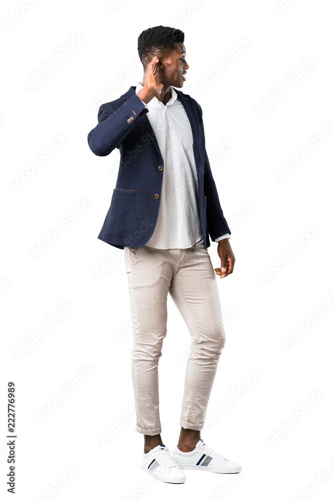 Full body of Handsome african american man wearing a jacket listening to something by putting hand on the ear on white background Full body of Handsome african american man wearing a jacket listening to something by putting hand on the ear on white background