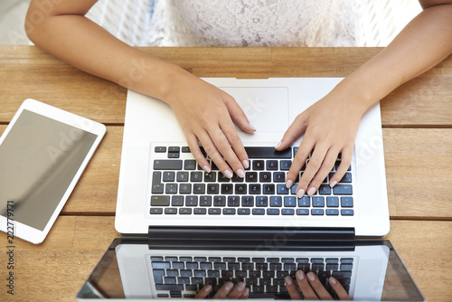 Close-up of woman typing on laptop