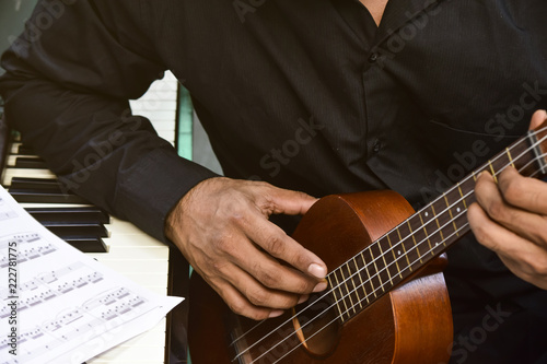 Closeup of playing the piano music instrument under sun flare light.