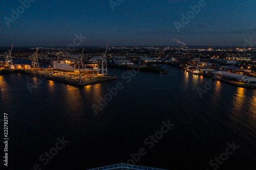 Aerial view of big cargo ship loading with containers at port of Hamburg  Germany. Beautiful sunset.