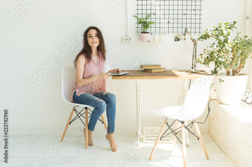 Education, people and technology concept - young student woman using digital tablet at home