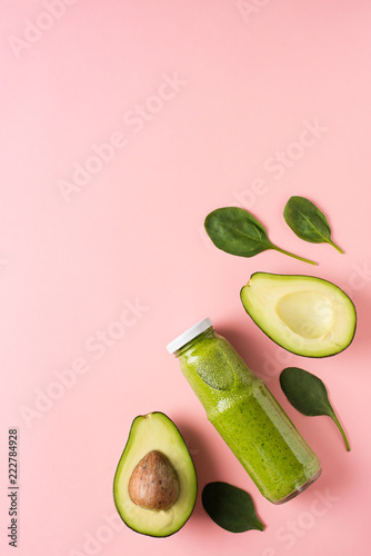 Green smooothie avocado and spinach in bottle on pink background. photo