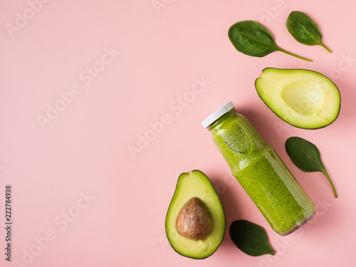 Green smooothie avocado and spinach in bottle on pink background. photo