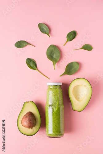 Fotografie Green smooothie avocado and spinach in bottle on pink background.