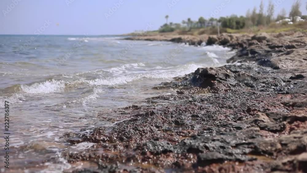 Waves of the Mediterranean Sea on the beach of Cyprus, rocky coast. Waves are beating against stones Waves of the Mediterranean Sea on the beach of Cyprus, rocky coast. Waves are beating against stones
