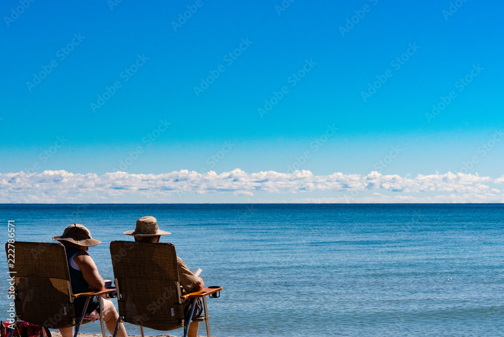 couple sitting on chairs and looking at the lake