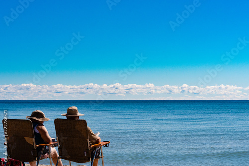 couple sitting on chairs and looking at the lake