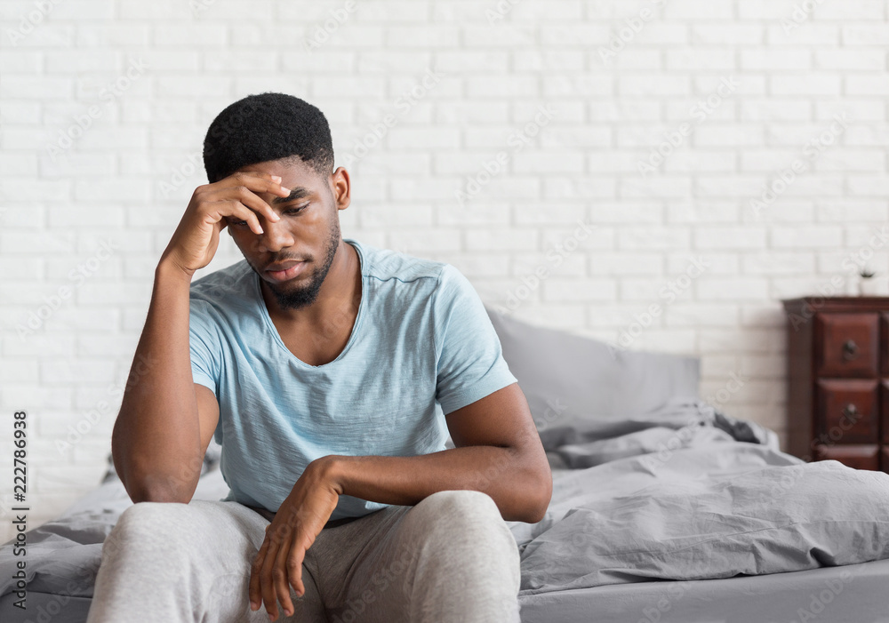 © Prostock-studio - Young depressed black man sitting on bed © Prostock-studio - Young depressed black man sitting on bed