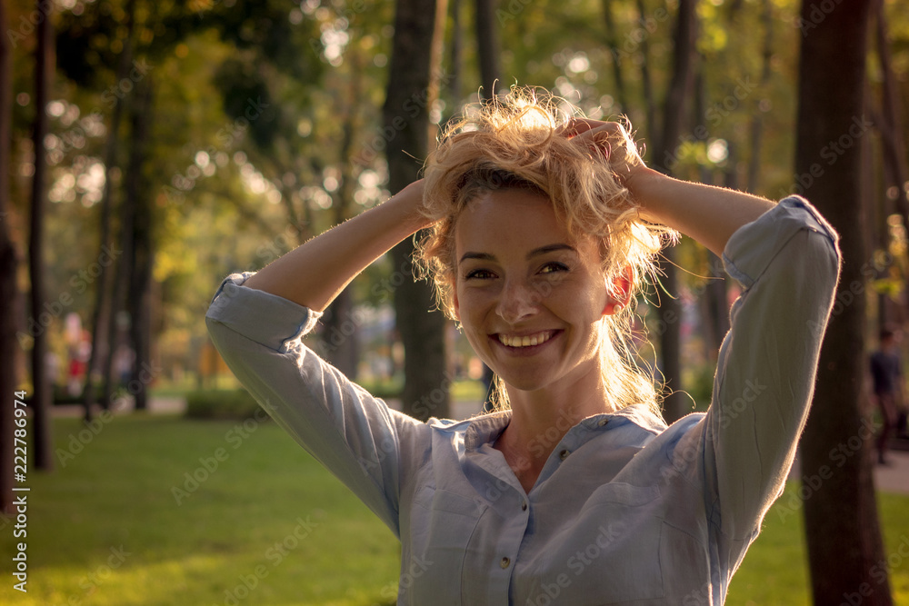 Portrait of a woman in a park with beautiful blond hair