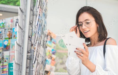 Girl chooses a postcard. Young female in the bookstore photo