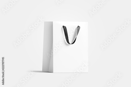 Blank white paper gift bag with black silk handle mockup, isolated, 3d rendering. Blank plastic packet mock up, side view. Beautiful package template. Craft bagful for present photo