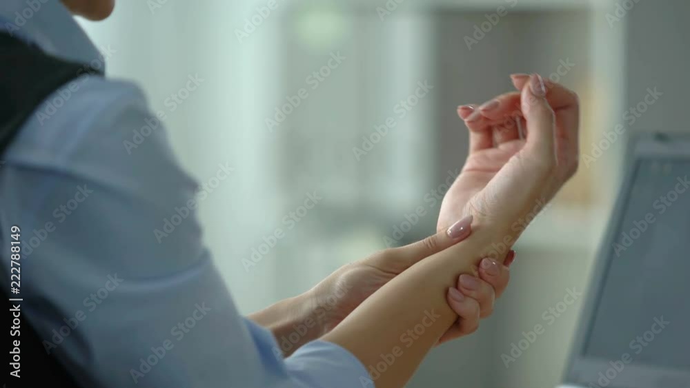 Female office manager typing on laptop, feeling wrist pain, joint inflammation Female office manager typing on laptop, feeling wrist pain, joint inflammation
