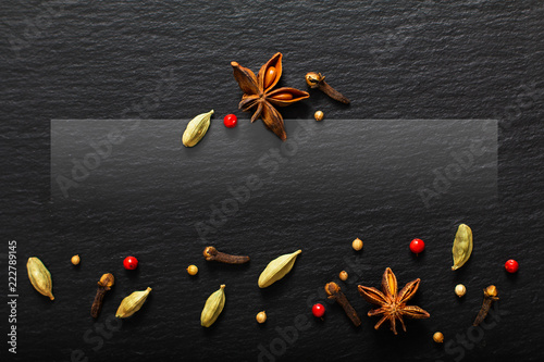 Food presentation background organic various exotic spieces on black slate board with copy space photo