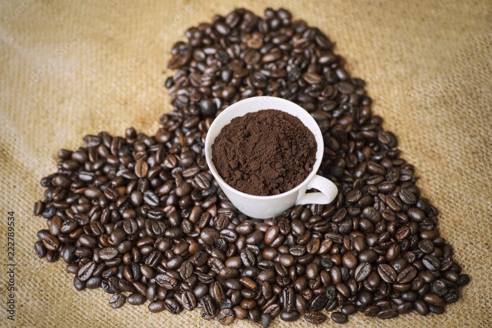 Ground coffee in a cup with coffee beans Ground coffee in a cup with coffee beans