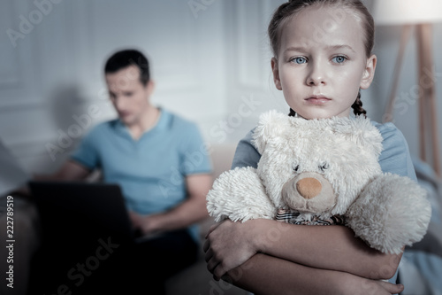 Sad thoughts. Lonely offended child thinking while standing in a room