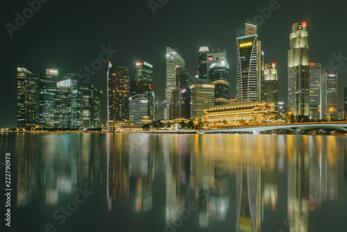 Singapore city skyline. Business district view. Downtown reflected in water at night in Marina Bay. Travel cityscape