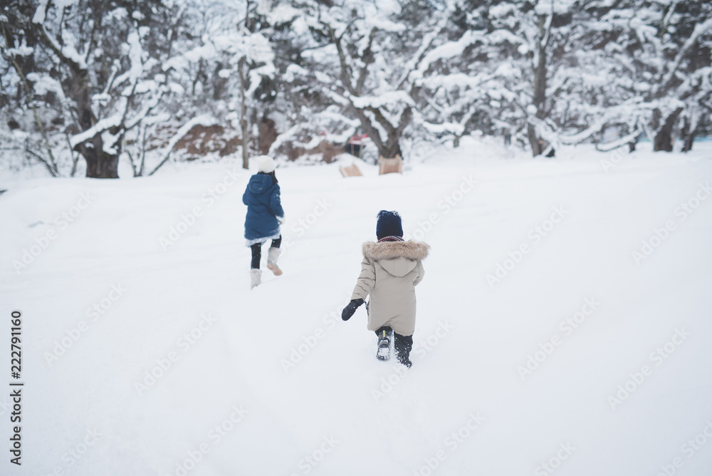Cute Asian children playing on snow in the park together , Aomori Japan