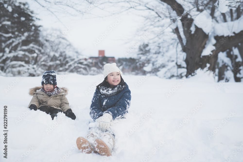 Fototapeta premium Cute Asian children playing on snow in the park together , Aomori Japan