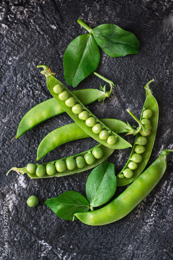 Sweet green peas on a dark background. Top view. Vertical food photo. Sweet green peas on a dark background. Top view. Vertical food photo.