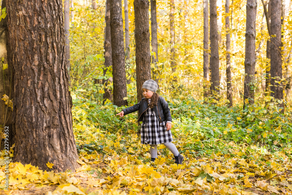Childhood, autumn and family concept - happy little child playing in the park