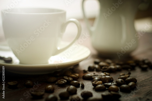 Coffee beans, glass and equipment for drinking coffee with warm light