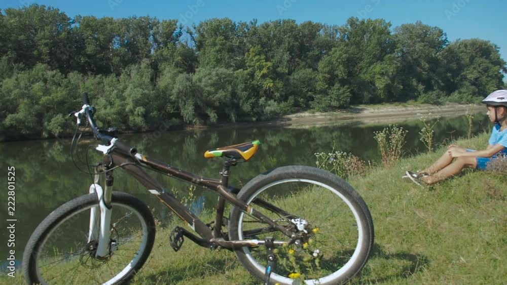 Bicycle tourism. A child with a bicycle rests on the nature. Bicycle tourism. A child with a bicycle rests on the nature.