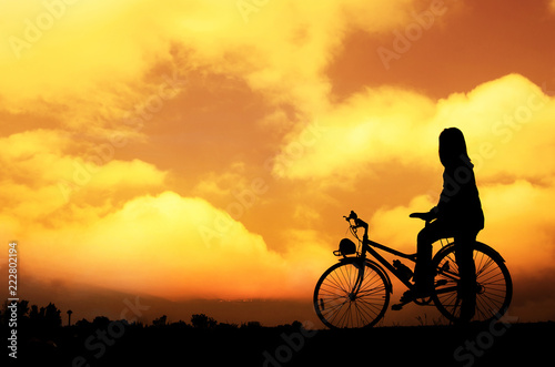 Silhouette woman with bicycle, walking, sunset background