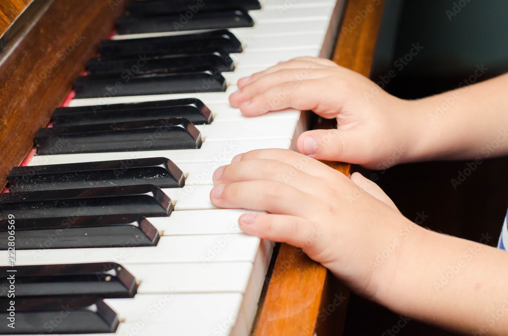 little boy plays a piano