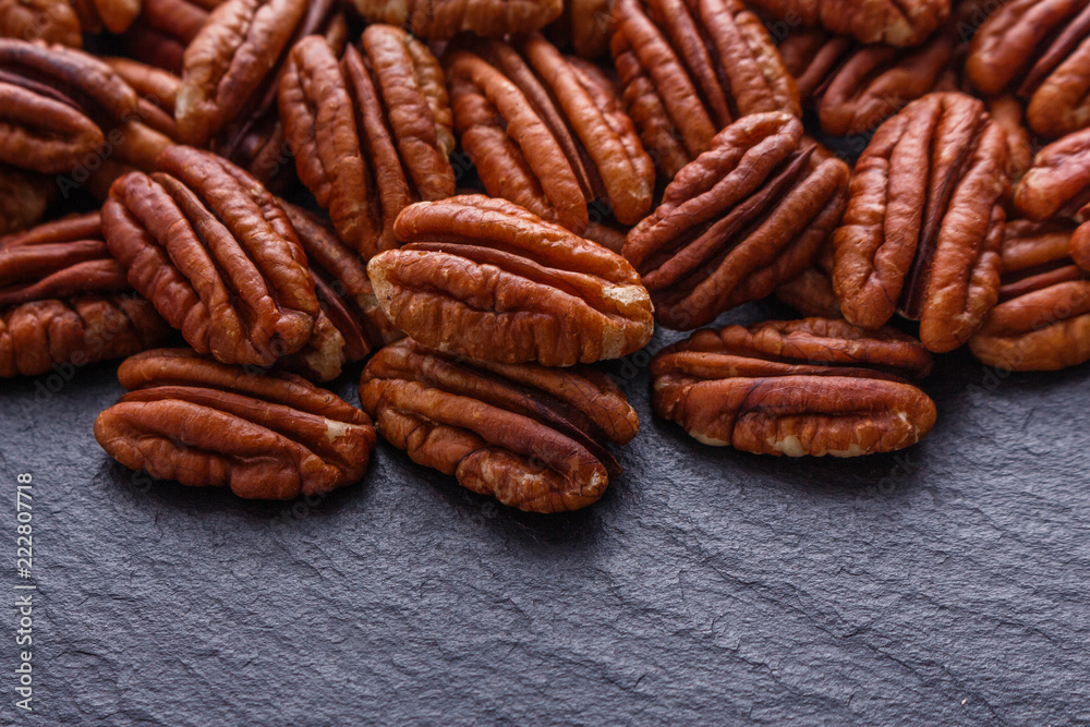 delicious pecan nuts on a dark stone background delicious pecan nuts on a dark stone background