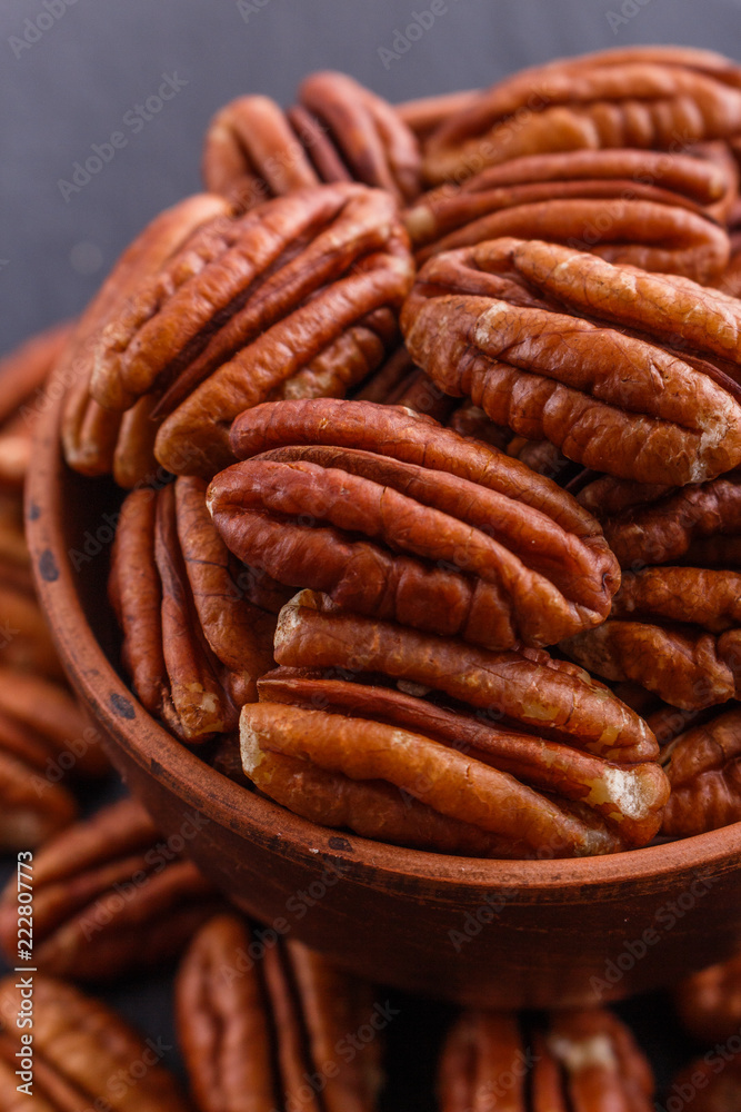 delicious pecan nuts on a dark stone background delicious pecan nuts on a dark stone background