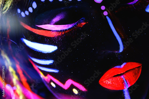 Woman with a neon makeup in ultraviolet light © blackday