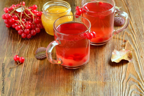 Red hot tea with viburnum berries in a glass cup, copy space