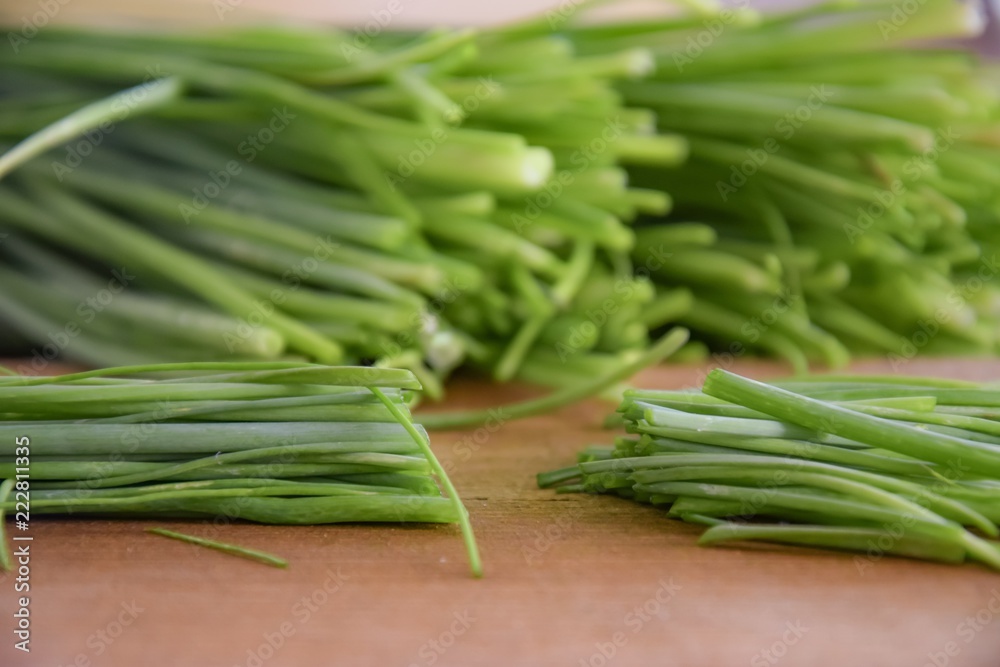 fresh bunch of chieves on a wooden cutting board fresh bunch of chieves on a wooden cutting board