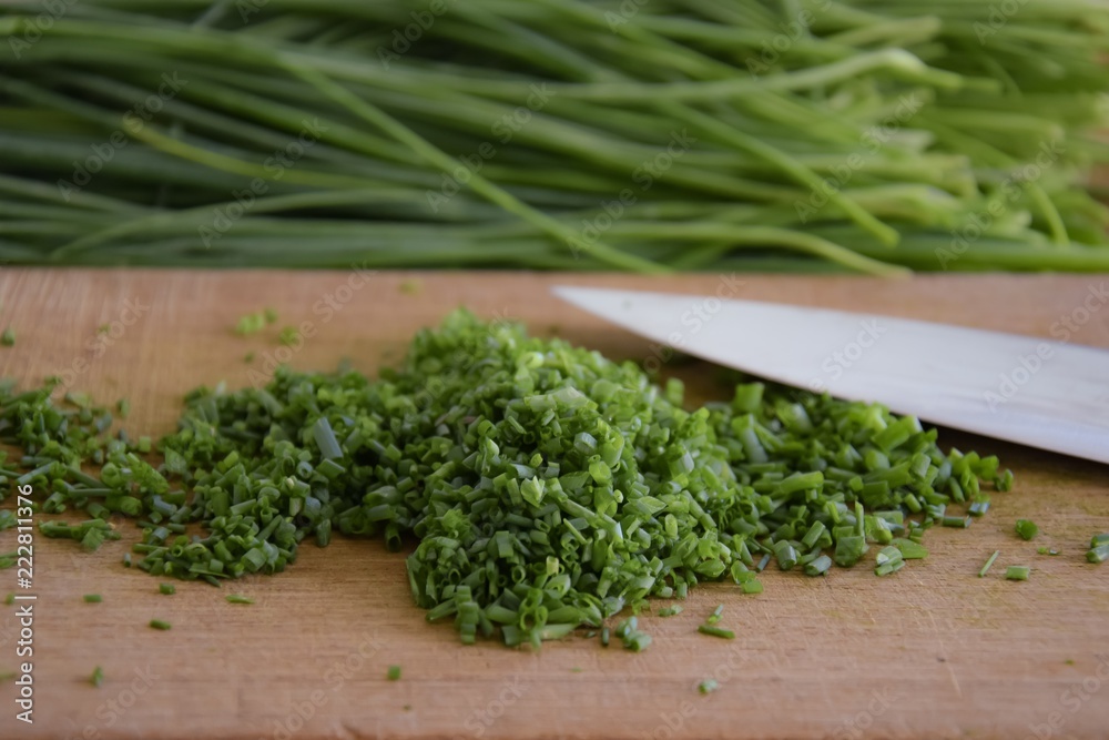 fresh bunch of chieves on a wooden cutting board fresh bunch of chieves on a wooden cutting board