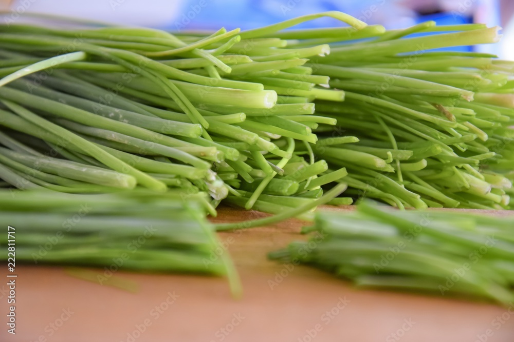 fresh bunch of chieves on a wooden cutting board fresh bunch of chieves on a wooden cutting board