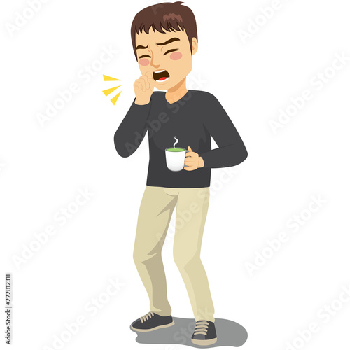 Young standing man coughing ill with fist in front of mouth and holding hot drink beverage