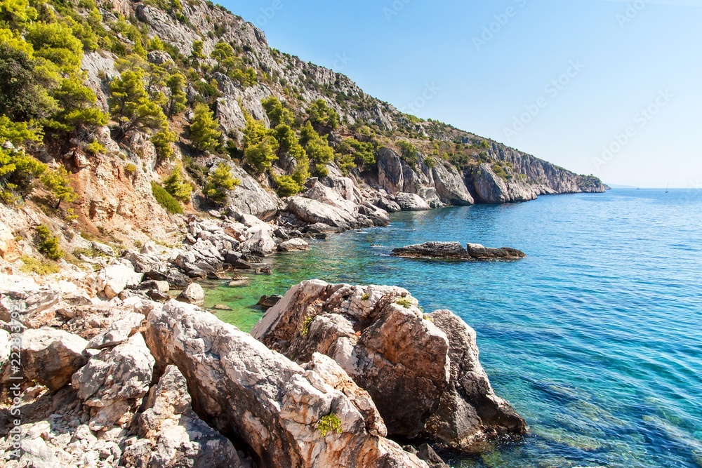 Croatian seashore. Coast of Hvar Island. Greetings from the sea. Sea and rocks in Croatia. Landscape of the Adriatic Sea. Hot summer day.