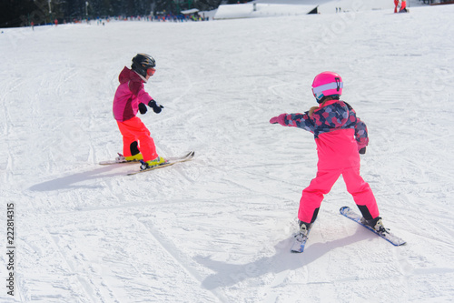 Ski instructor teaching young kids to go down ski slope
