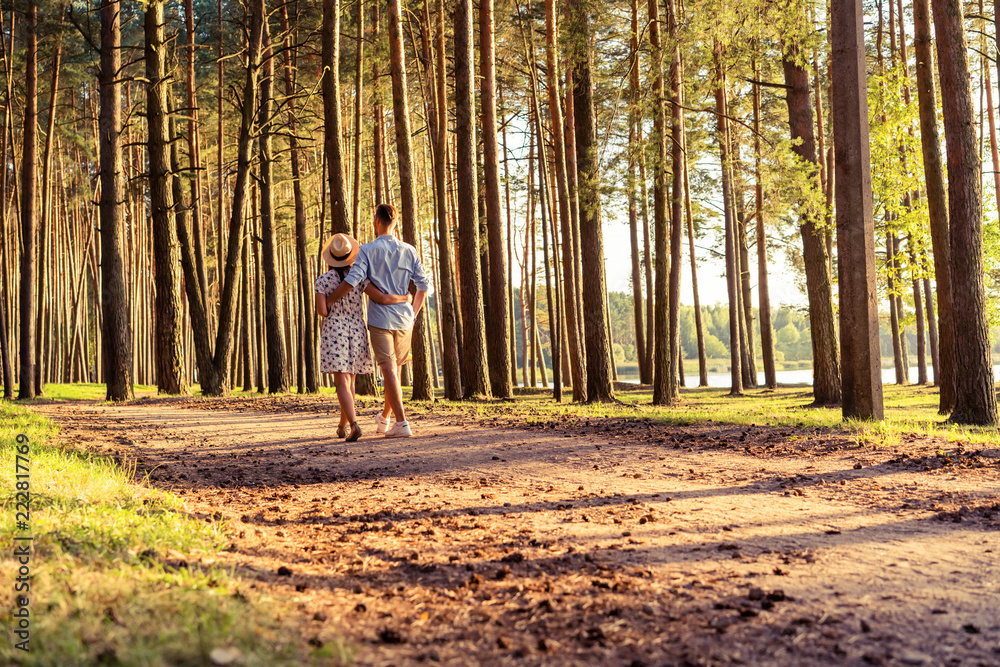 Young couple in love walking in the autumn park holding hands looking in the sunset. Young couple in love walking in the autumn park holding hands looking in the sunset.