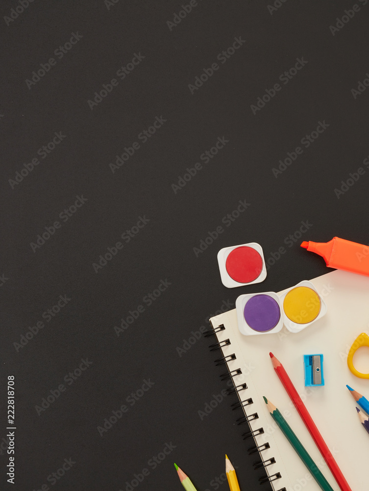 Notebook and school supplies on blackboard Notebook and school supplies on blackboard