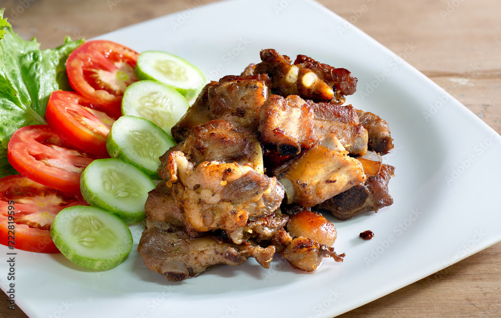 Fried deep pork ribs in white dish with vegetable thai food