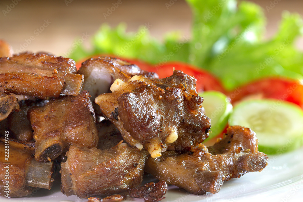 Fried deep pork ribs in white dish with vegetable thai food